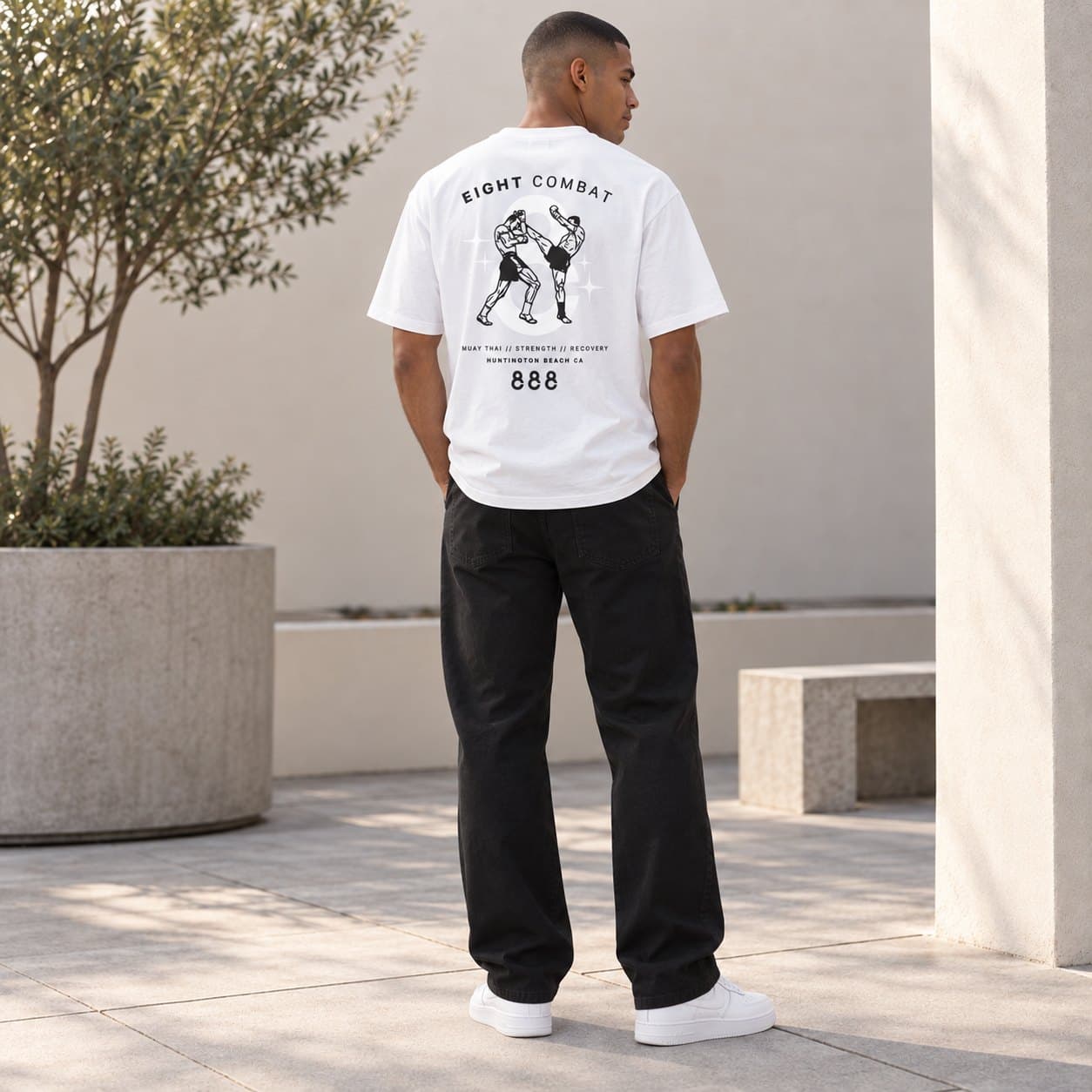 The back print of the white tee, worn outdoors
